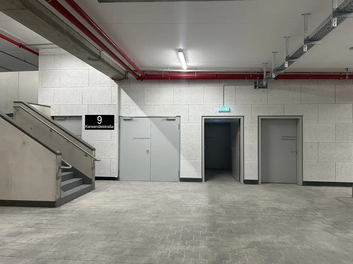 Zugangsbereich der Tiefgarage im Bauvorhaben ARGE Pling in München mit gedämmten Wänden und Treppenaufgang